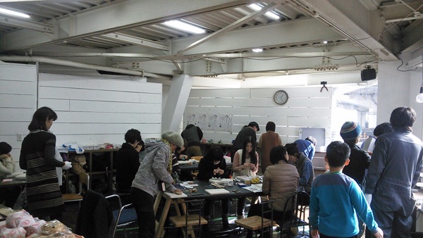  場所は梅田、新御堂高架下の都会の風景が見える大きな窓があるＯＺＣギャラリー。