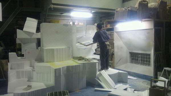 大きな発泡スチロールの塊を削る造形職人